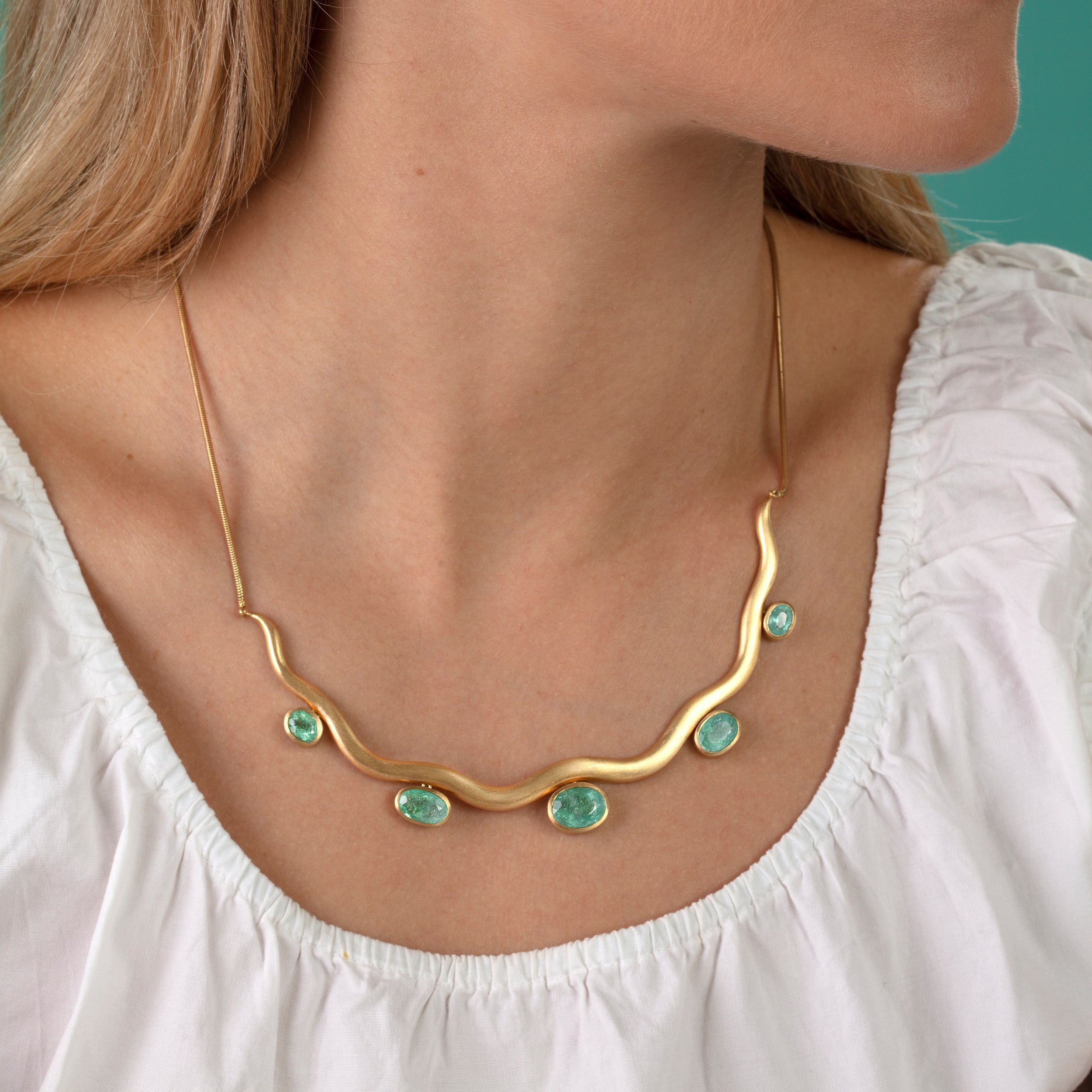 Model pictured wearing Paraiba tourmaline wave necklace and white blouse