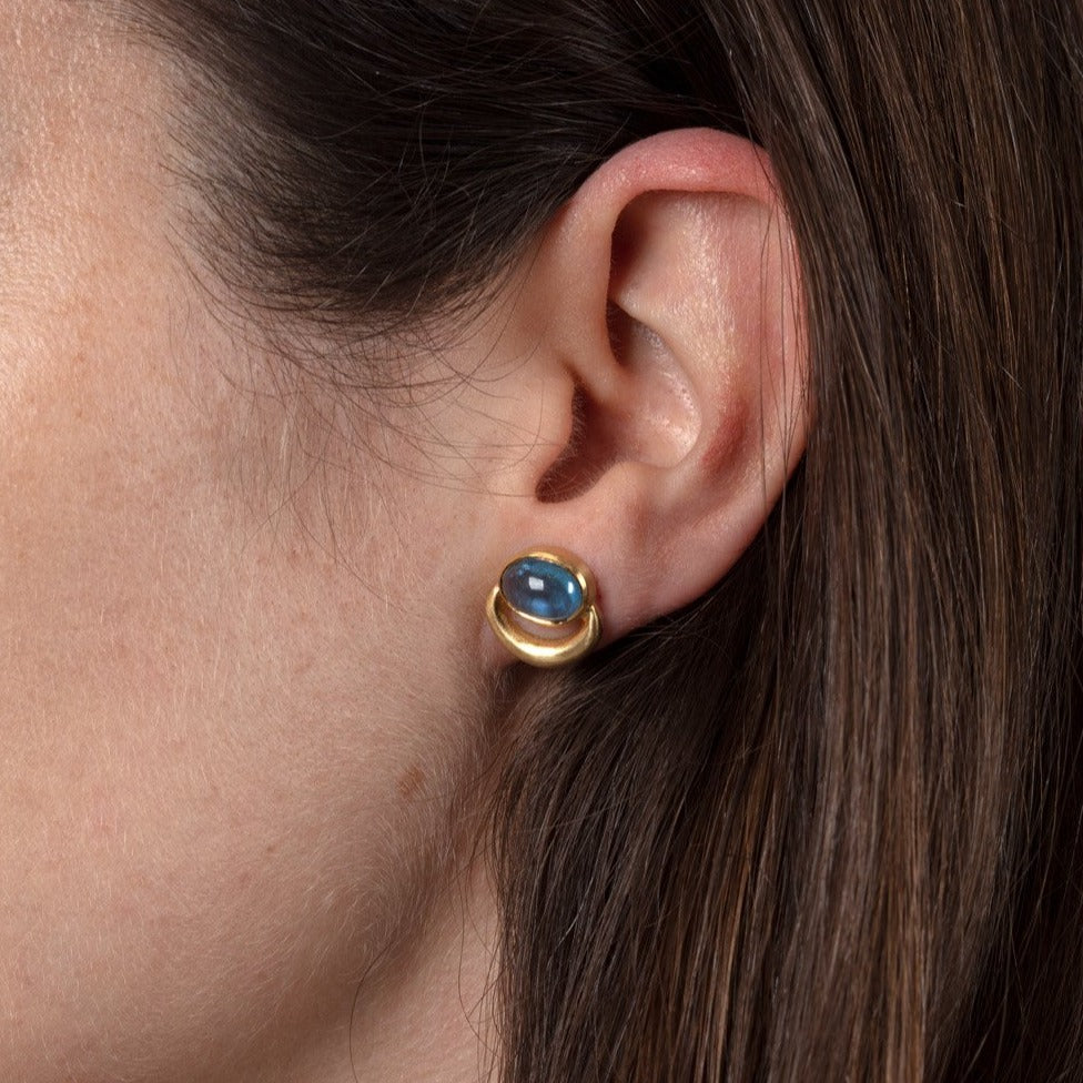 aquamarine and gold stud earrings shown on a model