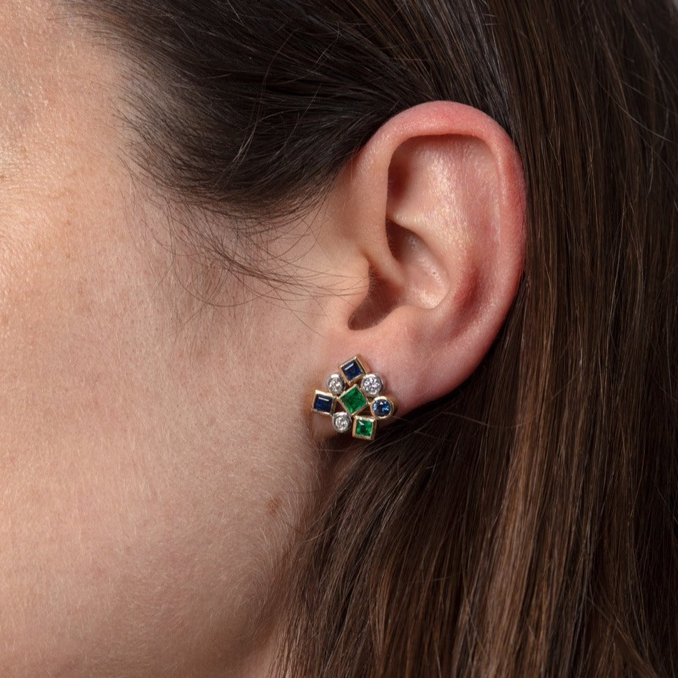 diamond, sapphire and emerald gold earrings on ear