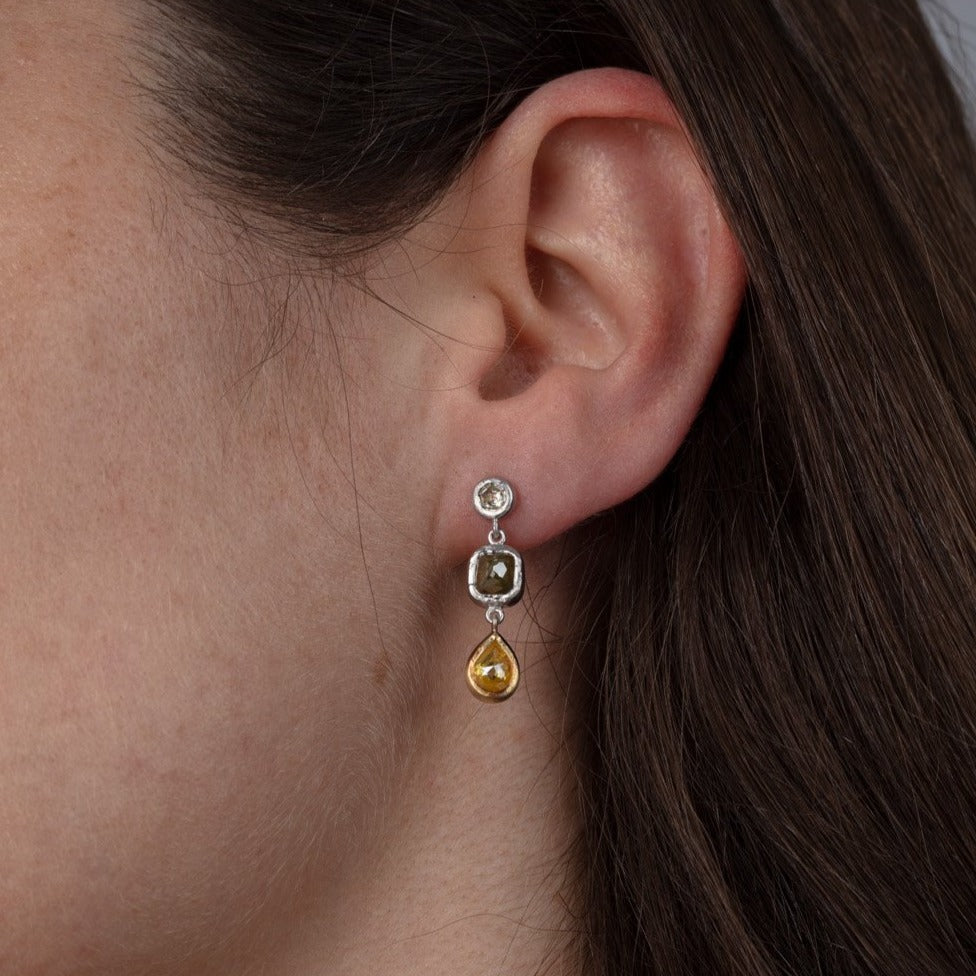 diamond and gold three tier drop earrings shown on a model