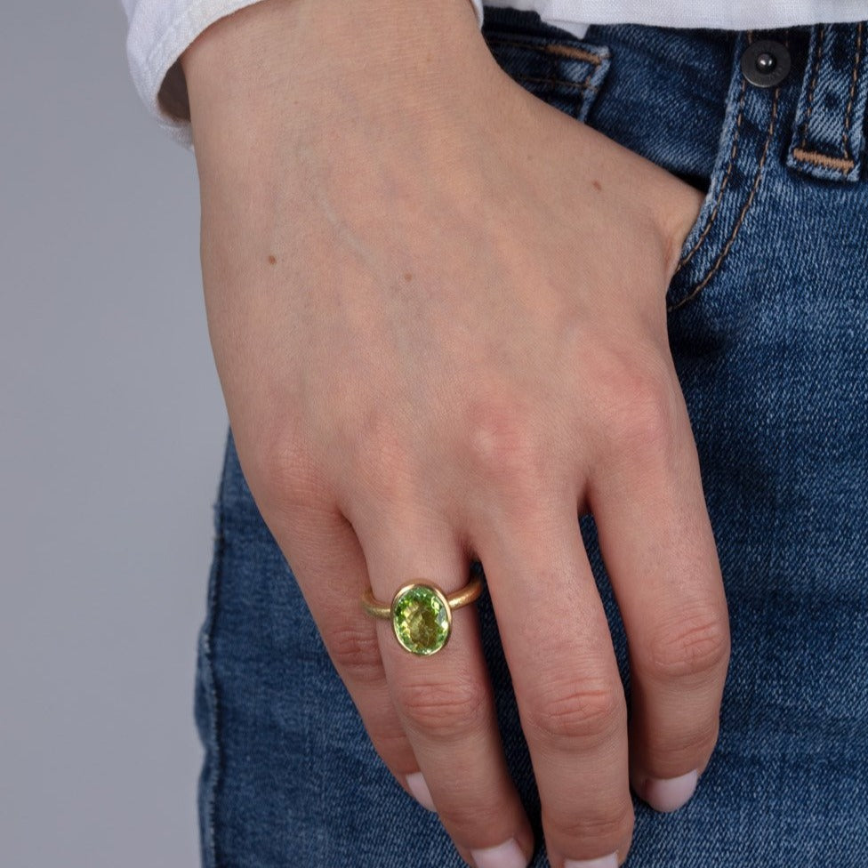 Green paraiba tourmaline and gold ring on a model