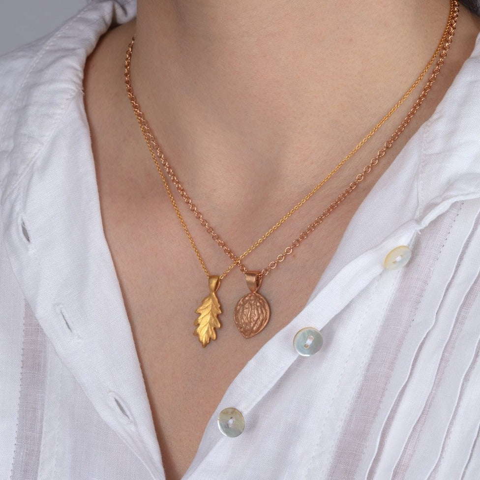 red gold walnut pendant necklace shown on a model