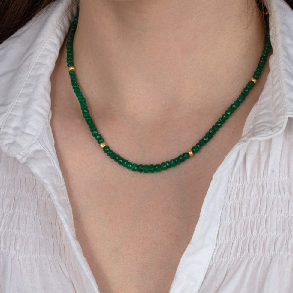 emerald and gold bead necklace shown on a model