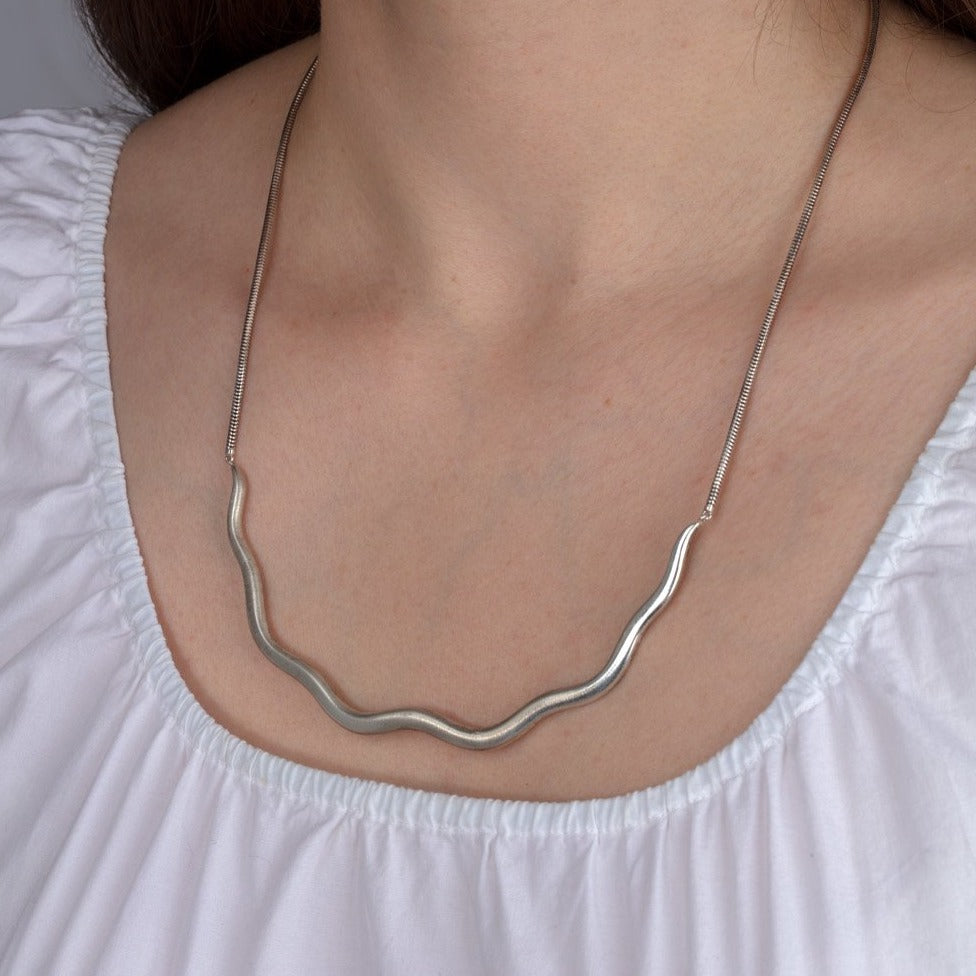 silver wave necklace shown on a model