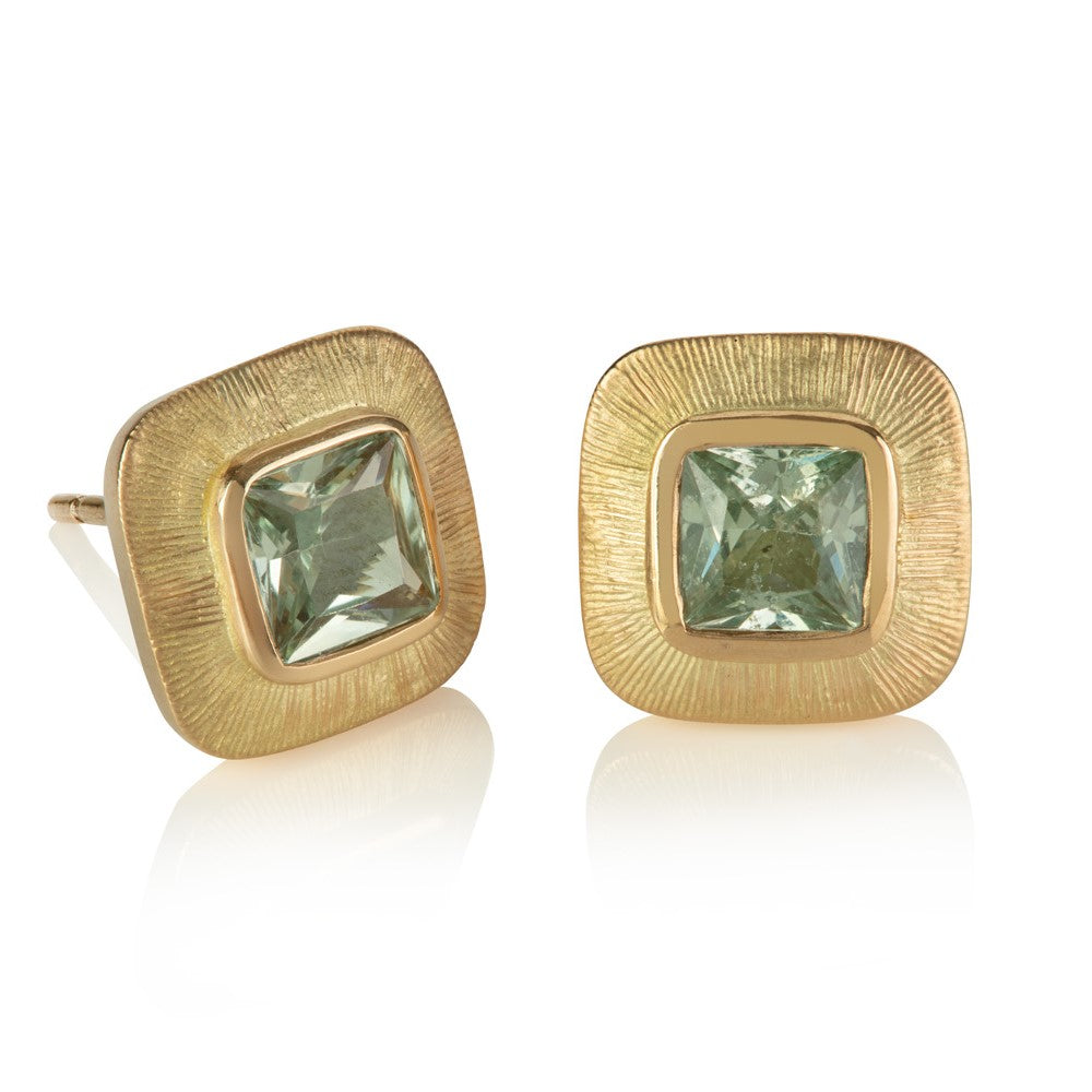Stud earrings with cushion shaped pale green sapphires in wide yellow gold engraved borders