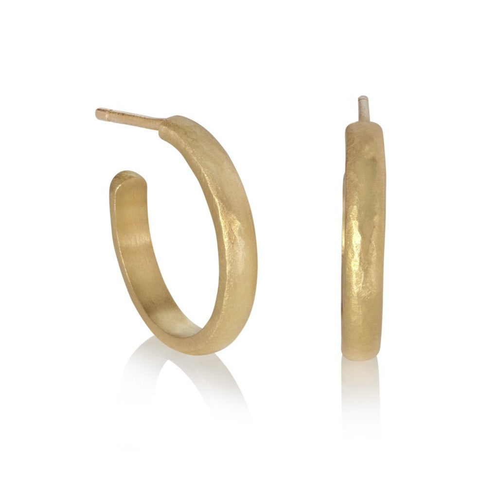 Gold hoop earrings on white background