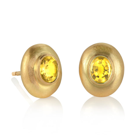 Yellow gold and yellow sapphire stud earrings shown on a white background