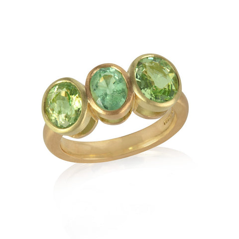 Yellow gold ring with three bezel set oval Paraiba tourmalines, of varied green tones
