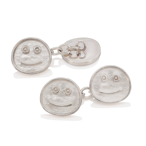 Silver smiley face cufflinks on a white background