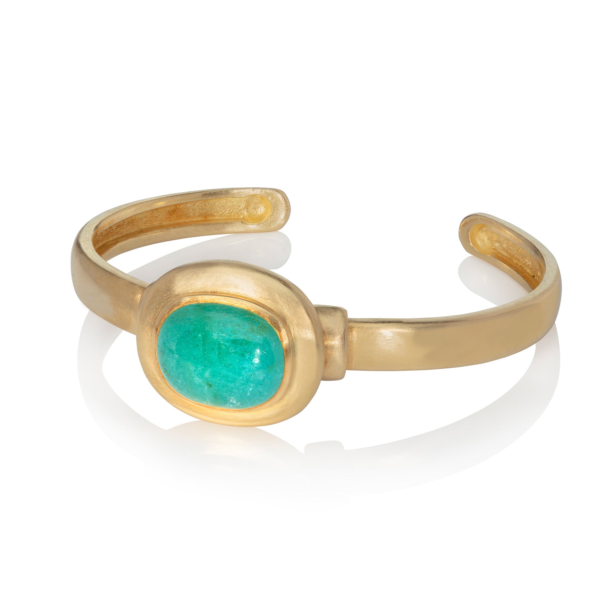 Huge Paraiba tourmaline cabochon set in yellow gold, mounted on yellow gold bangle with hand polished finish, on white background
