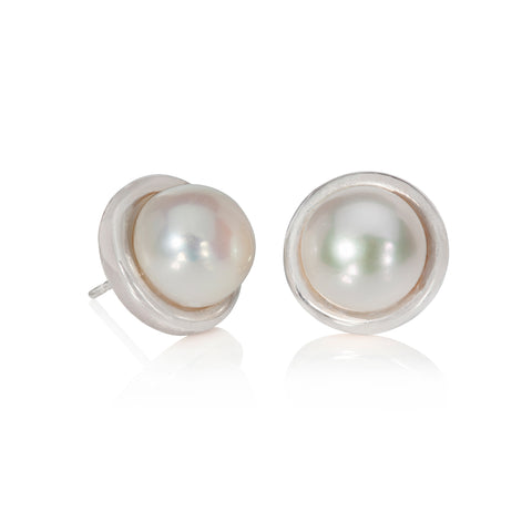 Silver button pearl earrings, on a white background