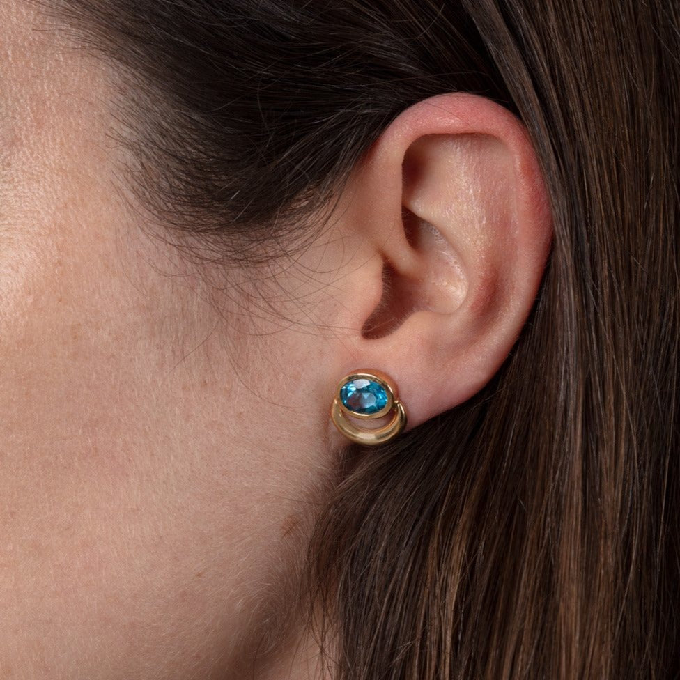 gold and blue topaz earrings shown on model