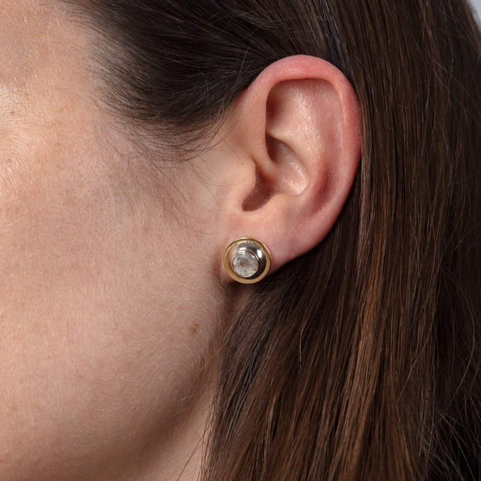gold and diamond stud earrings on ear