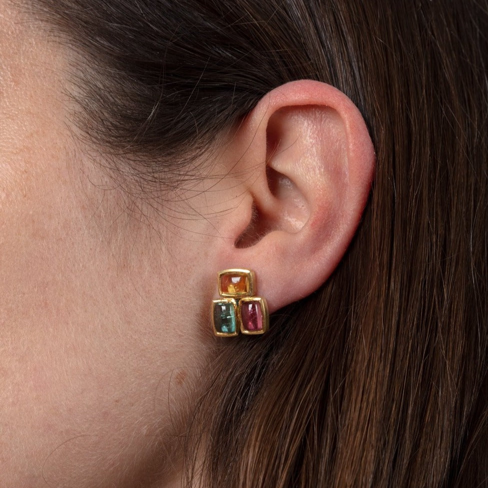 yellow gold and tourmaline stud earrings shown on a model