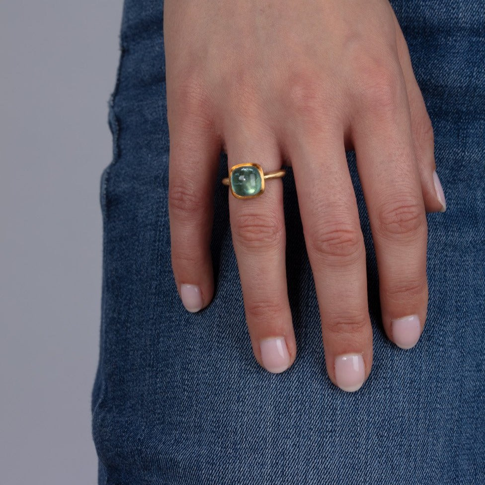 gold and aquamarine ring shown on model