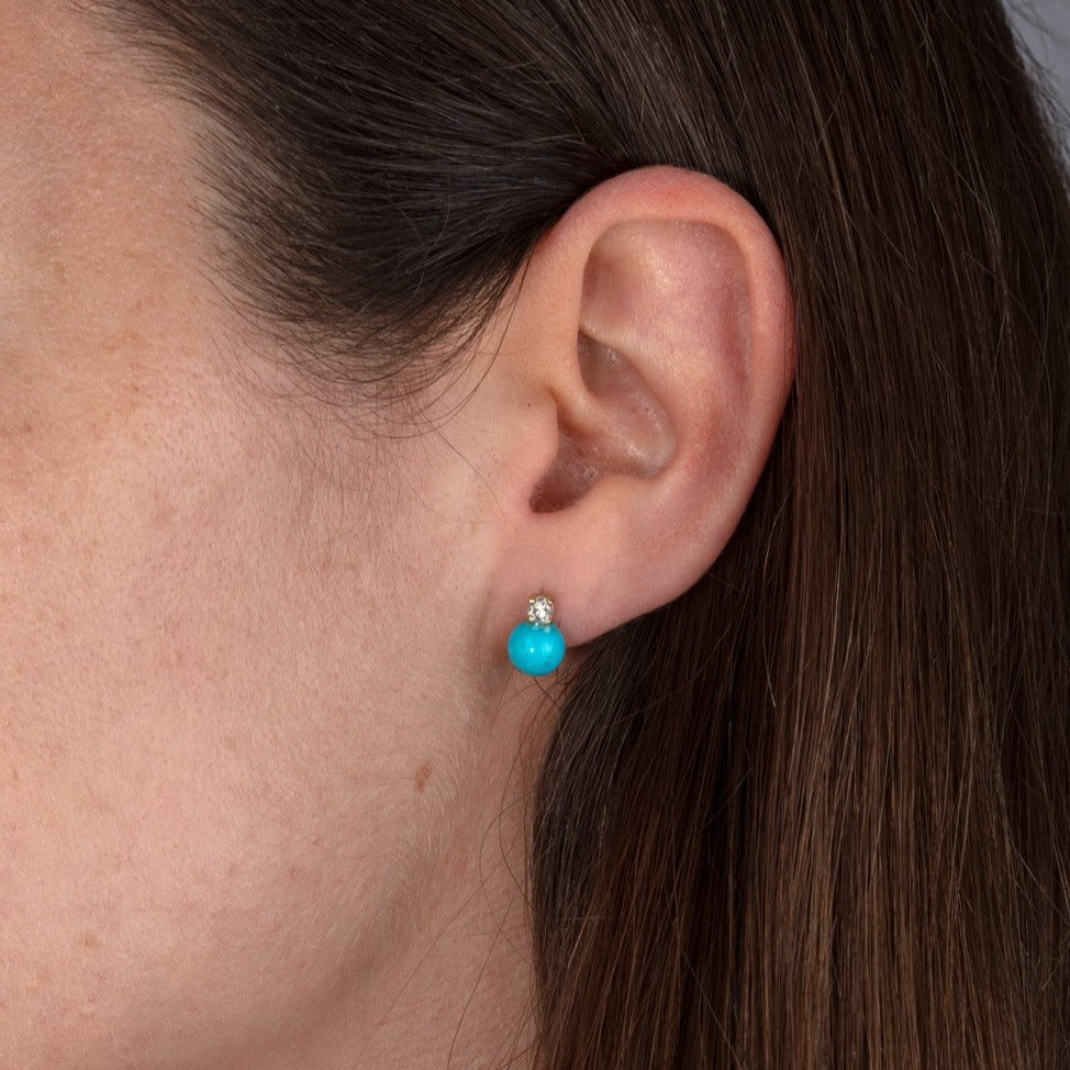 diamond and turquoise stud earrings on ear