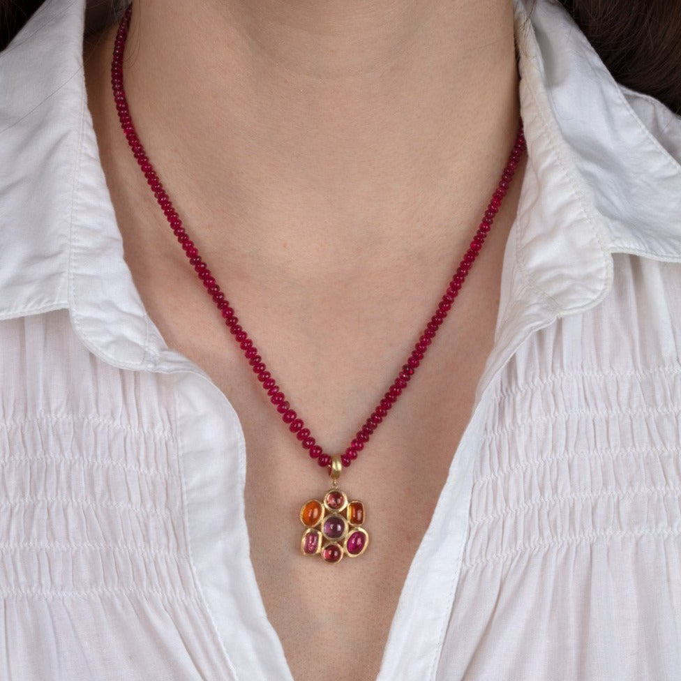 tourmaline and gold pendant necklace shown on a model