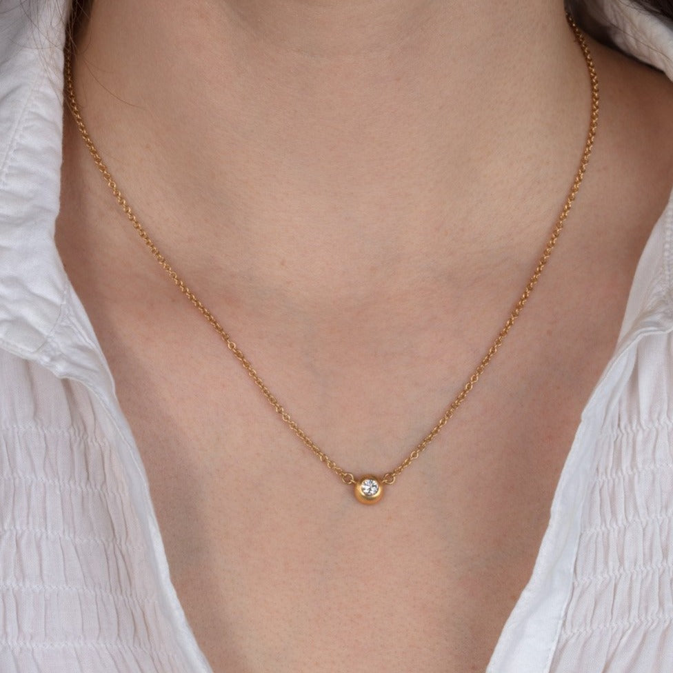 diamond and gold necklace shown on a model