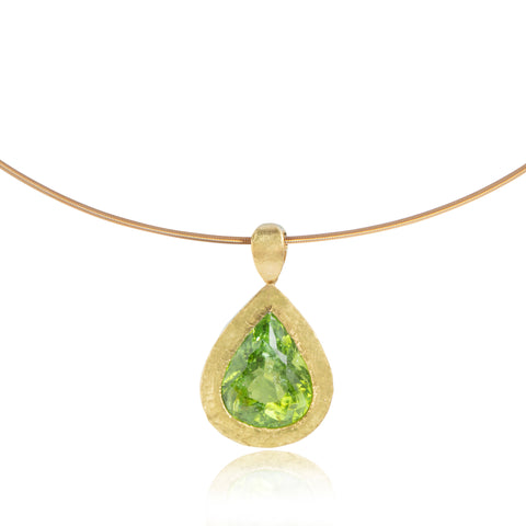 Green pear shaped Paraiba tourmaline pendant pictured on white background