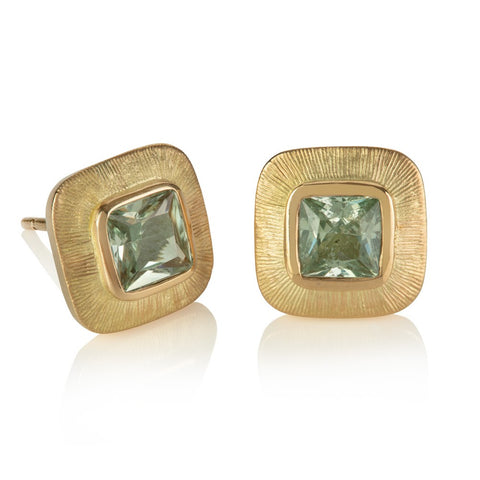 Stud earrings with cushion shaped pale green sapphires in wide yellow gold engraved borders