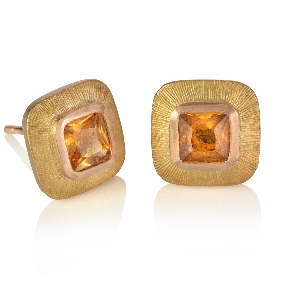 Orange cushion cut sapphires set in wide red gold engraved borders 