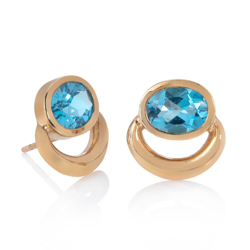 Yellow gold bull ring stud earrings set with oval blue topaz