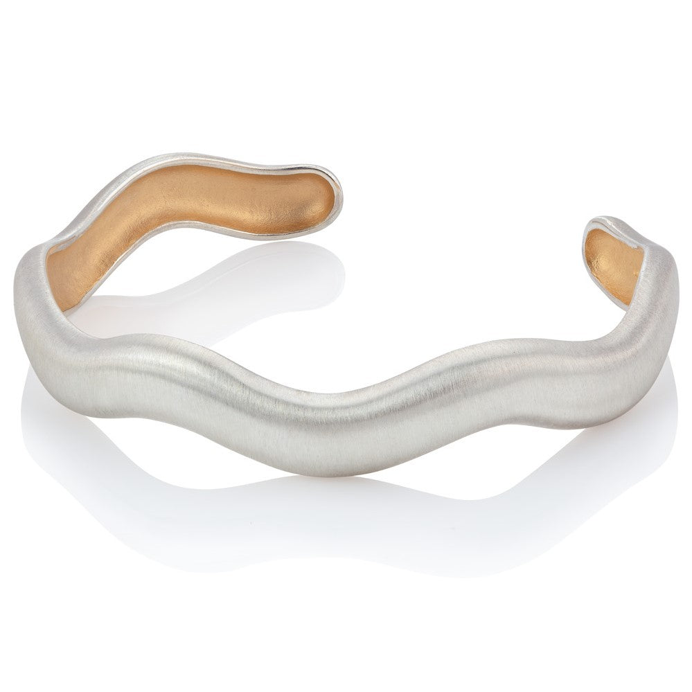 Wavy silver bangle, with yellow gold micro-plating inside on white background