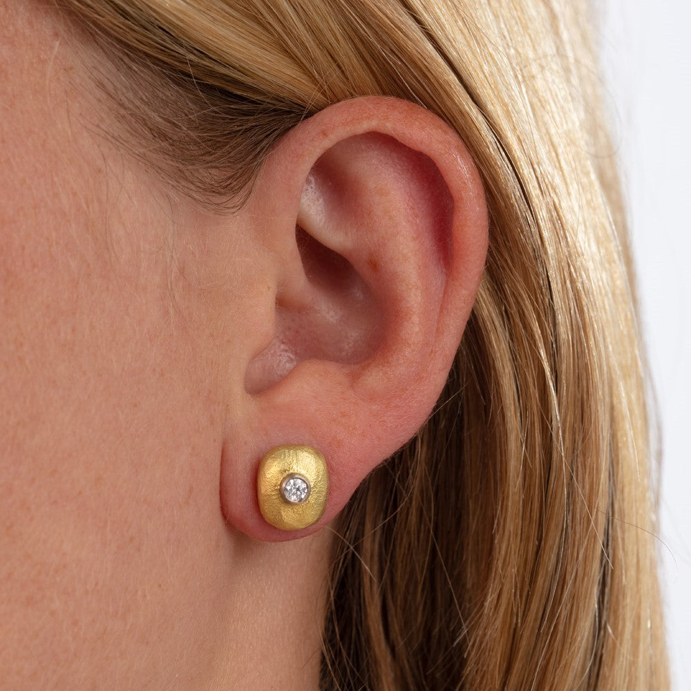 Close up of pebble stud earrings on model's ear