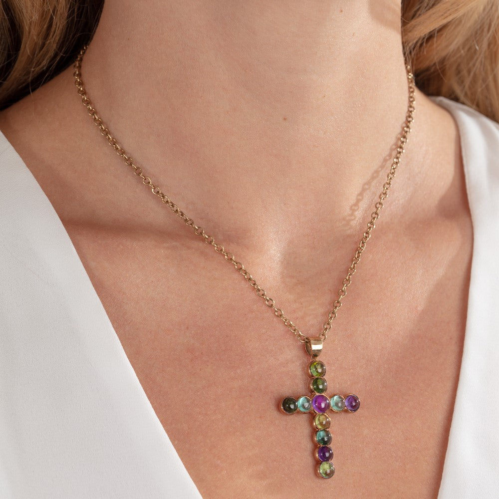 Large yellow gold cross, set with multicoloured cabochon gems, hung on yellow gold chain worn by model