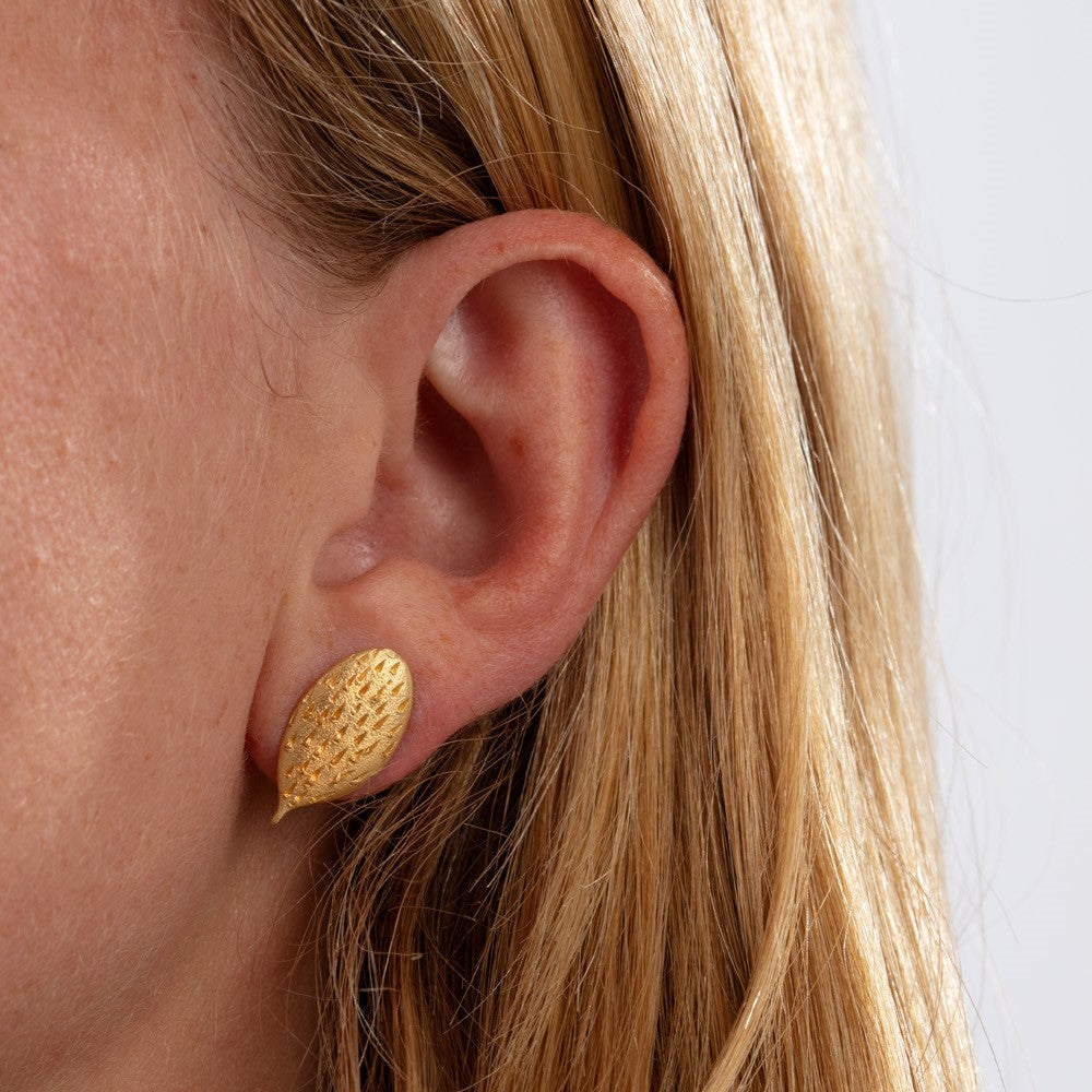 Close up of cactus earring on model's ear