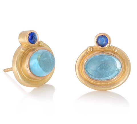 Stud earrings in yellow gold set with large oval aquamarine cabochons, with small round blue sapphires above