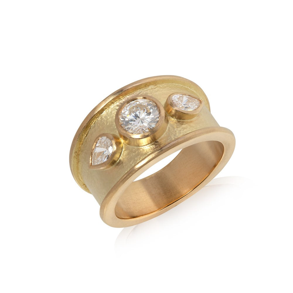 Wide yellow gold ring with thick border set with round cut diamond with two pear shaped diamonds, hammered texture finish