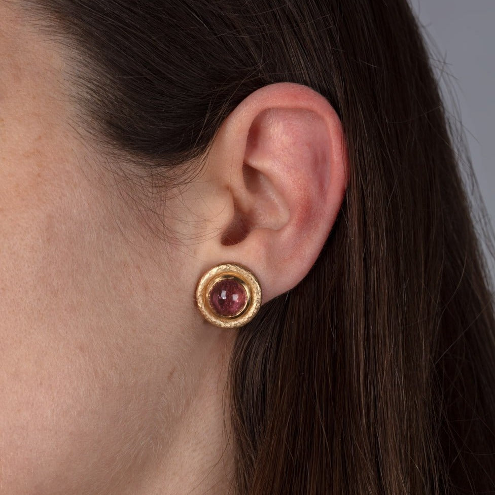 pink tourmaline yellow gold earrings shown on a model