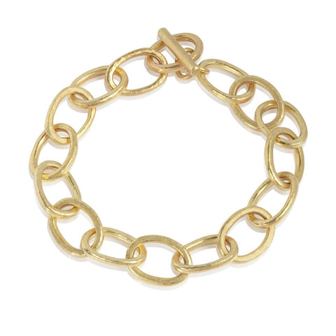 Chunky yellow gold link bracelet, with hammered texture on white background