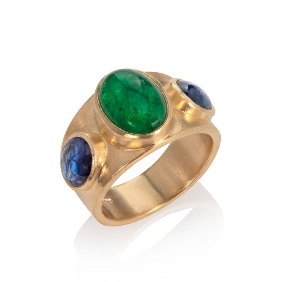 Emerald and sapphire wide gold ring on a white background