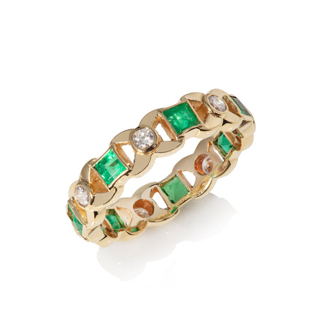 Diamond and emerald kisses eternity ring on white background