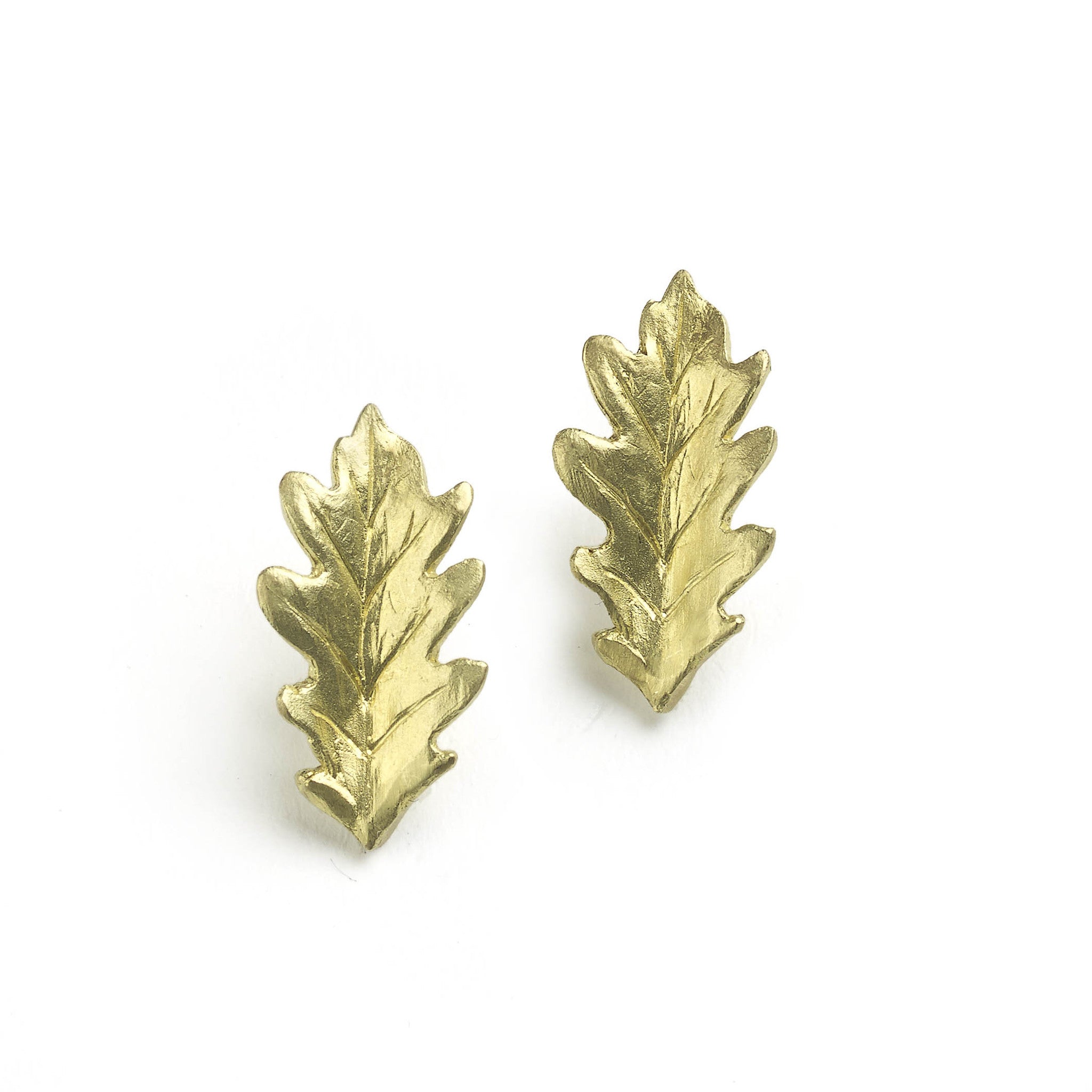 Yellow gold oak leaf earrings pictured on a white background