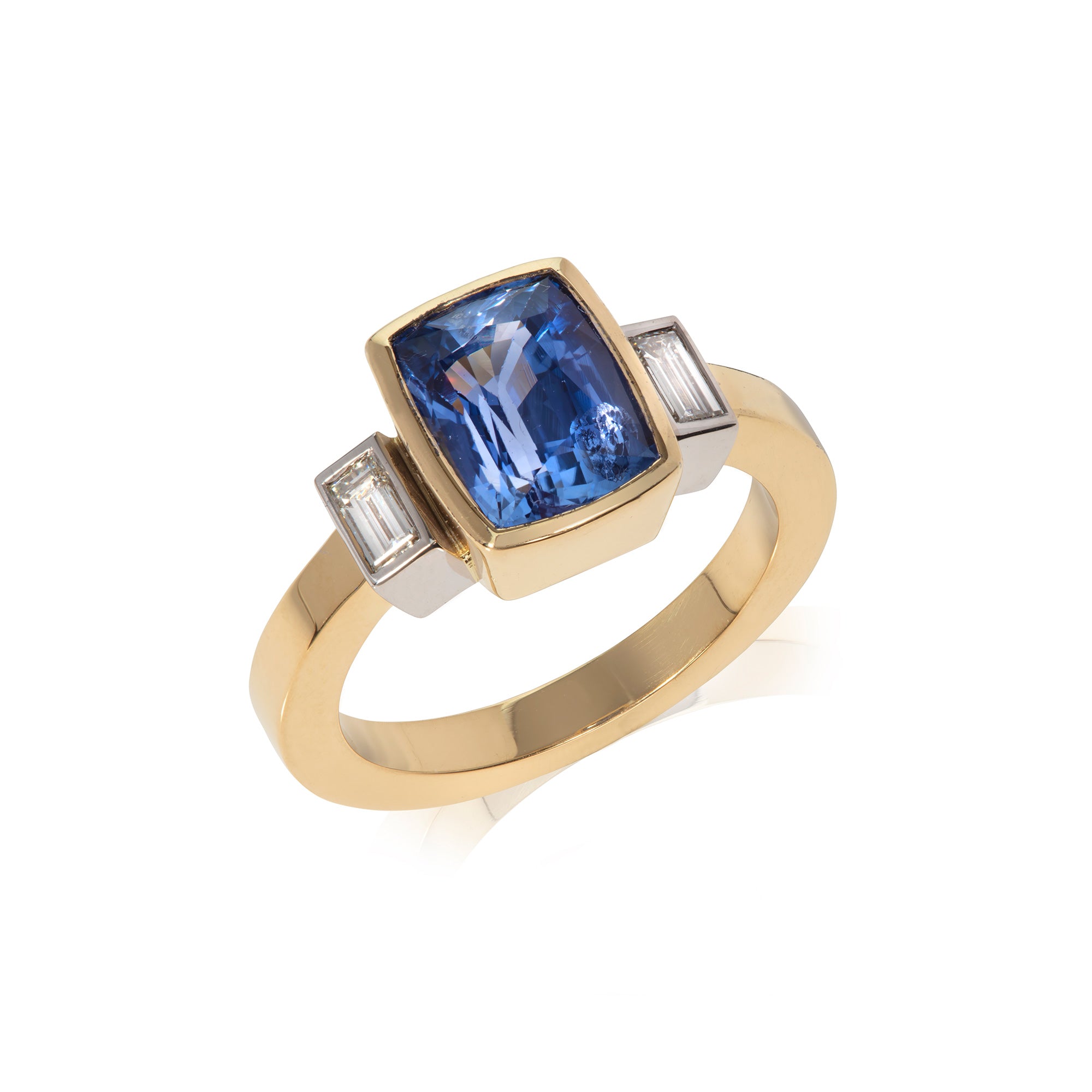 Sapphire and diamond baguette three stone ring photographed on white background