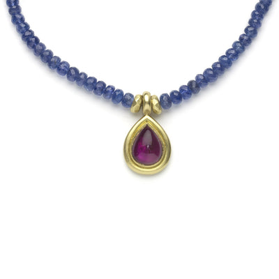 Tanzanite bead necklace with yellow gold pendant set with pear shaped rubellite cabochon