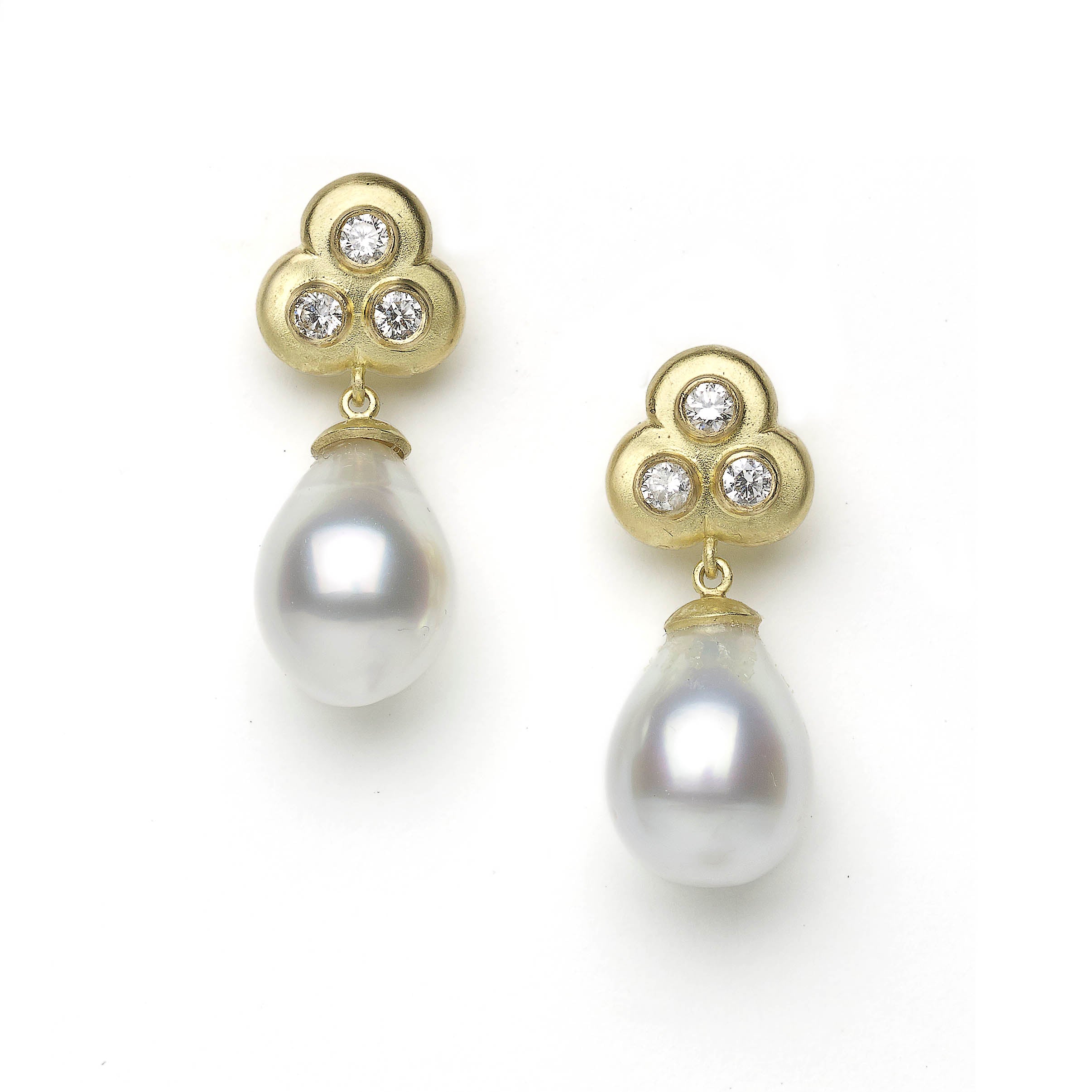Trefoil diamond and pearl drop earrings on white background
